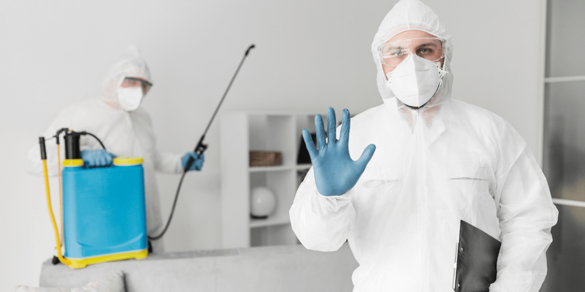 How to Pest-Proof Your Home Before Fall and Winter in Reno, NV 1 Two men in protective clothing and masks stand in a room, emphasizing safety and health precautions.